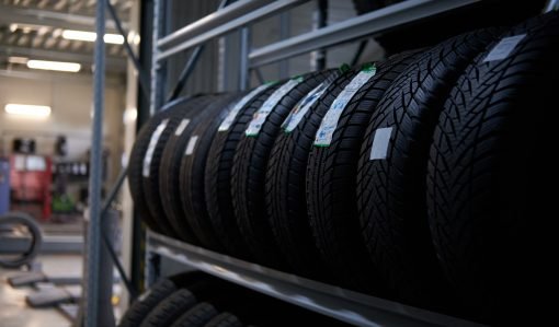 Brand new big variety of car's tyres on shelf with prices at store or warehouse.
